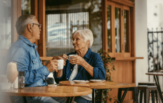 a couple of seniors having a conversation and drinking coffee