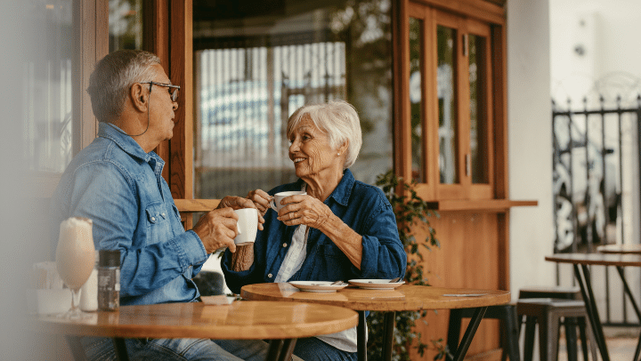 a couple of seniors having a conversation and drinking coffee