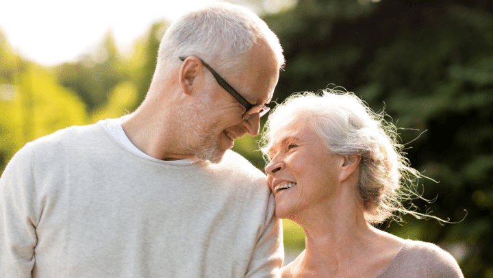 a senior couple looking into each other's eyes and smiling together